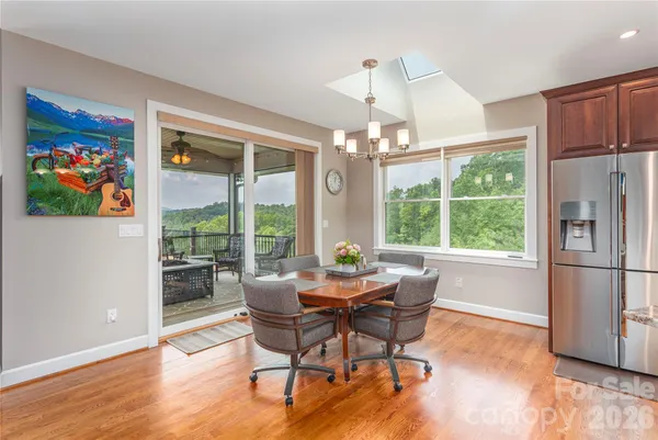a dining room with furniture a chandelier and wooden floor