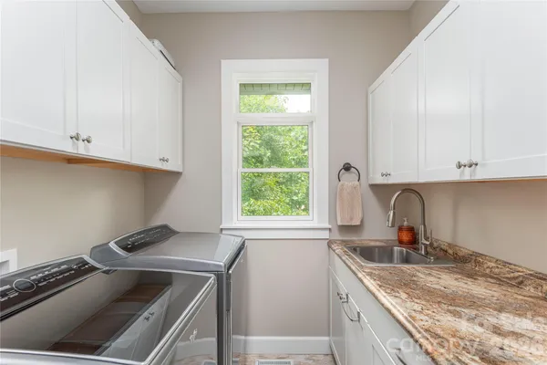 a kitchen with granite countertop a sink stove and cabinets