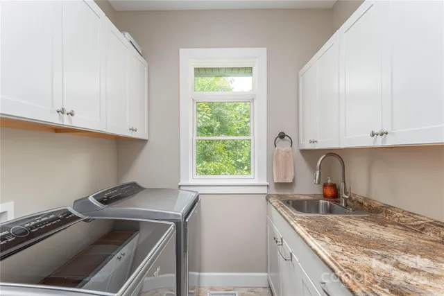 a kitchen with granite countertop a sink stove and cabinets
