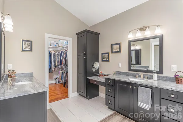 a bathroom with a granite countertop sink a mirror and a bathtub