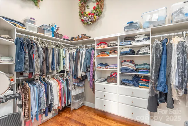 a view of walk in closet with clothes and shoes
