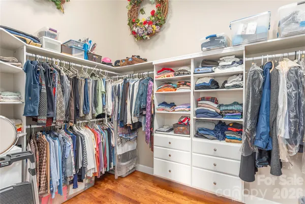 a view of walk in closet with clothes and shoes