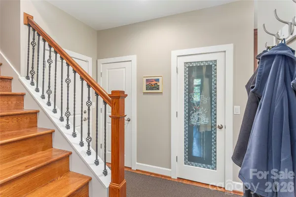 a view of staircase with lots of frames on wall and a window