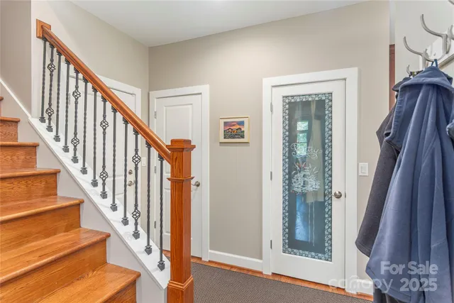 a view of staircase with lots of frames on wall and a window