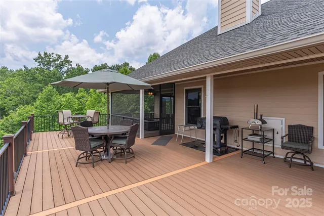 a roof deck with table and chairs under an umbrella with wooden floor