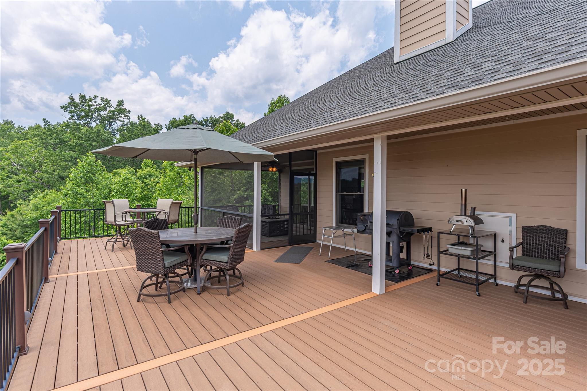 930 Big Raven Lane Saluda, NC 28773 - Photo 30 of 35 a roof deck with table and chairs under an umbrella with wooden floor
