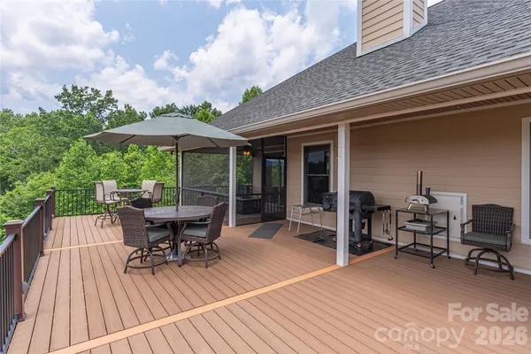 a roof deck with table and chairs under an umbrella with wooden floor