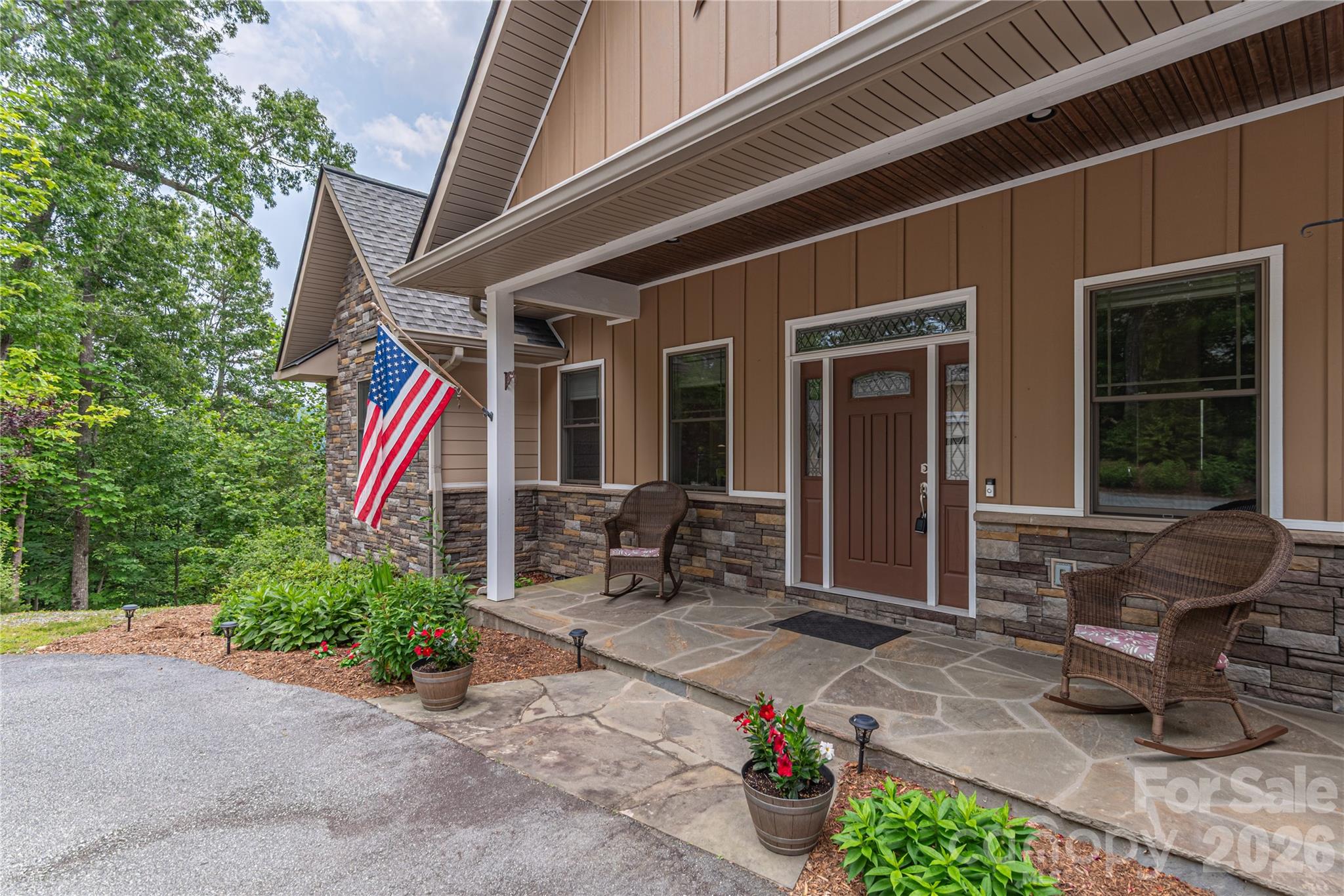 930 Big Raven Lane Saluda, NC 28773 - Photo 9 of 35 a front view of a house with outdoor seating and a potted plant