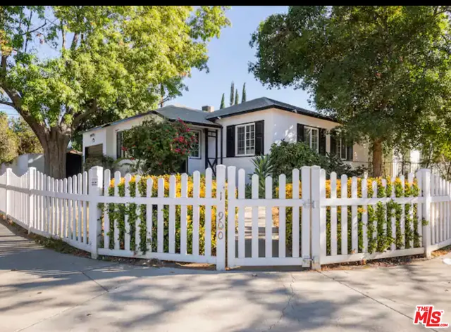 a front view of white house with a small yard
