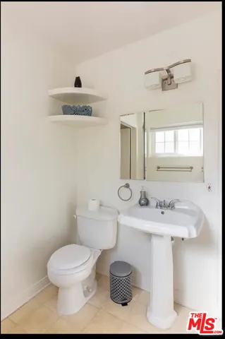 a bathroom with a sink toilet and mirror