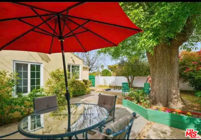 a patio with a table and chairs under an umbrella