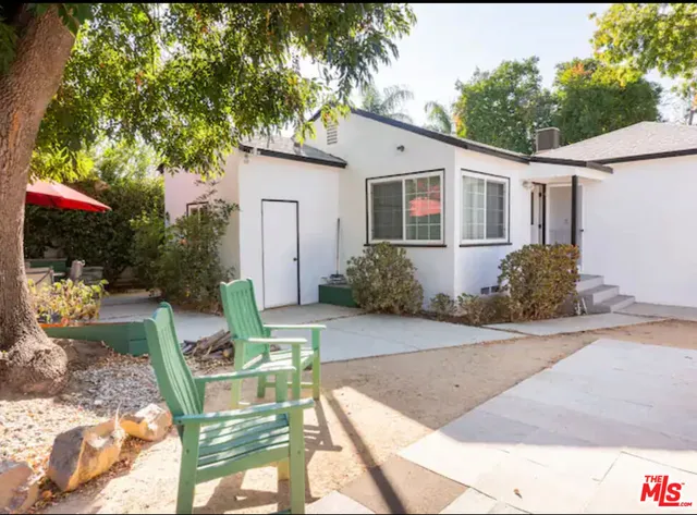 a view of backyard of house with outdoor seating