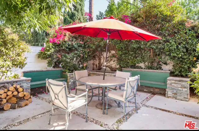 a patio with a table and chairs under an umbrella