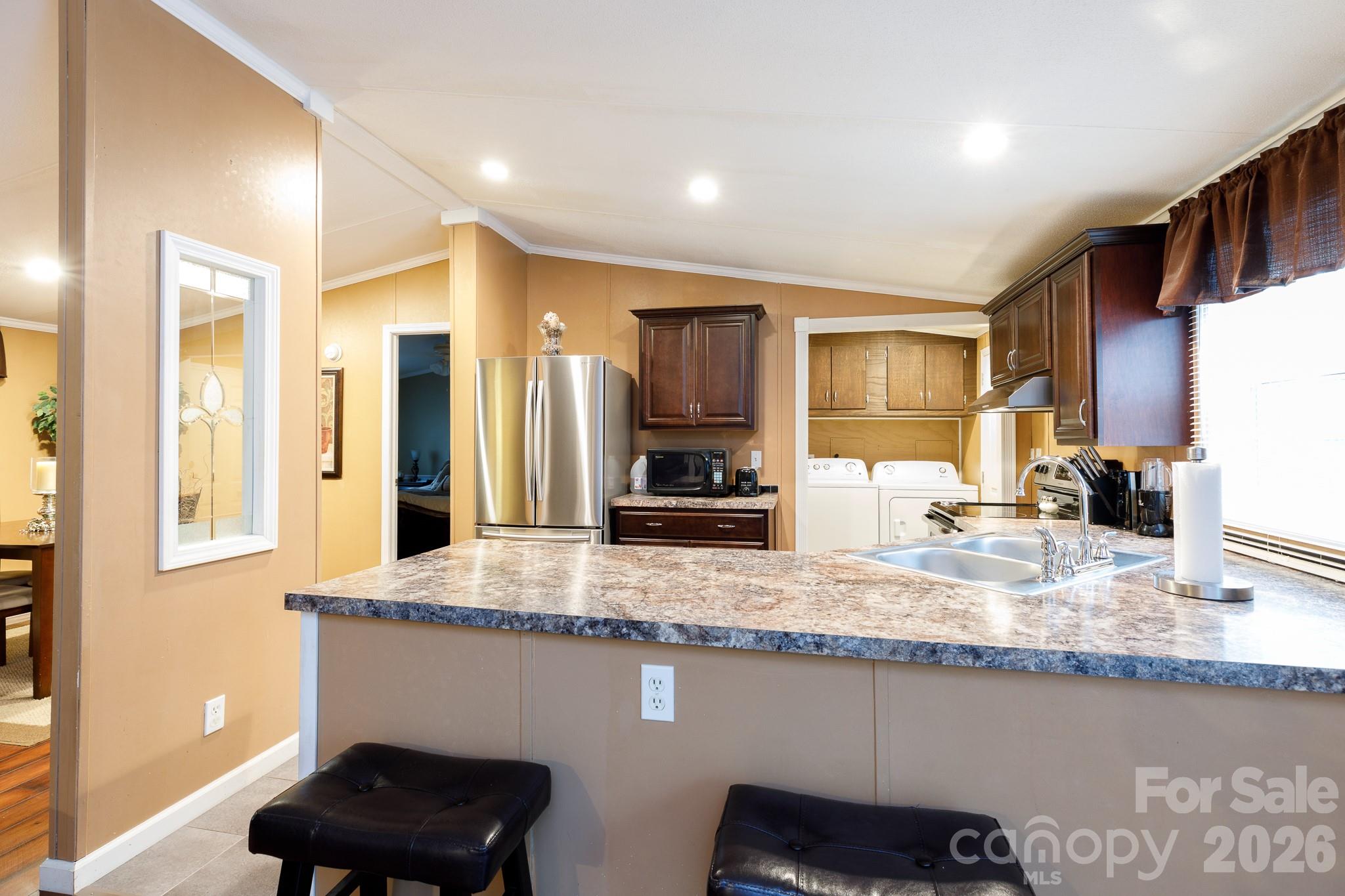 652 Sutton Spring Road York, SC 29745 - Photo 11 of 28 a kitchen with granite countertop kitchen island stainless steel appliances a sink and a refrigerator