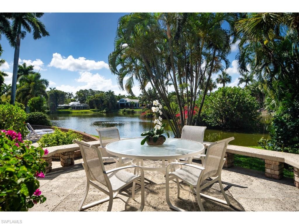 2610 Half Moon Walk Naples, FL 34102 - Photo 7 of 10 a table and chairs with potted plants and big trees