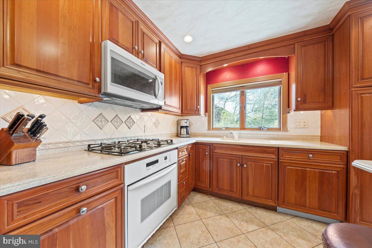 12 Green Tree Road Stratford, NJ 08084 - Photo 13 of 33 a kitchen with stainless steel appliances granite countertop a stove a sink and a microwave