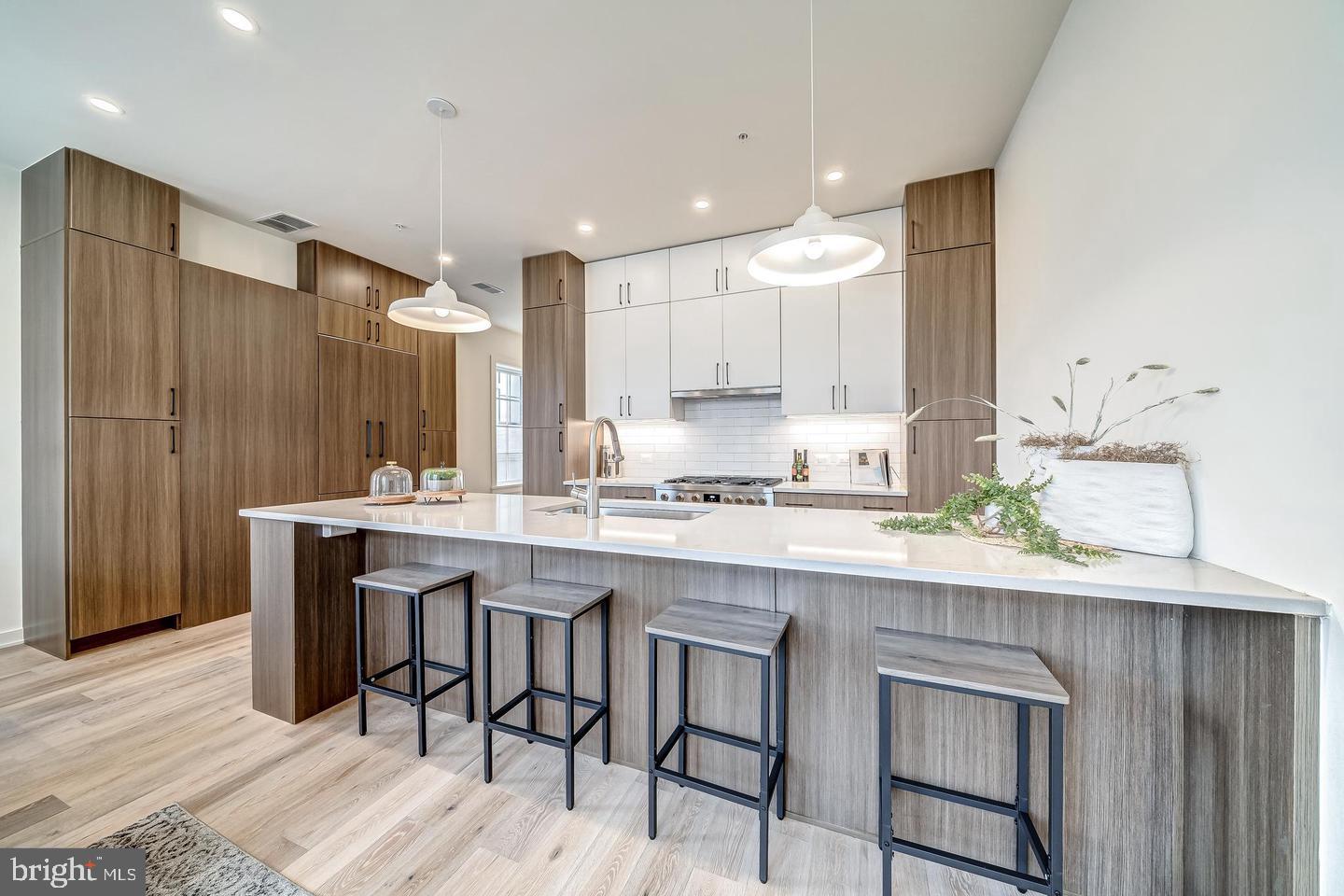 442 R Street Northwest, Unit A Washington, DC 20001 - Photo 23 of 25 a kitchen with kitchen island granite countertop wooden cabinets and white appliances