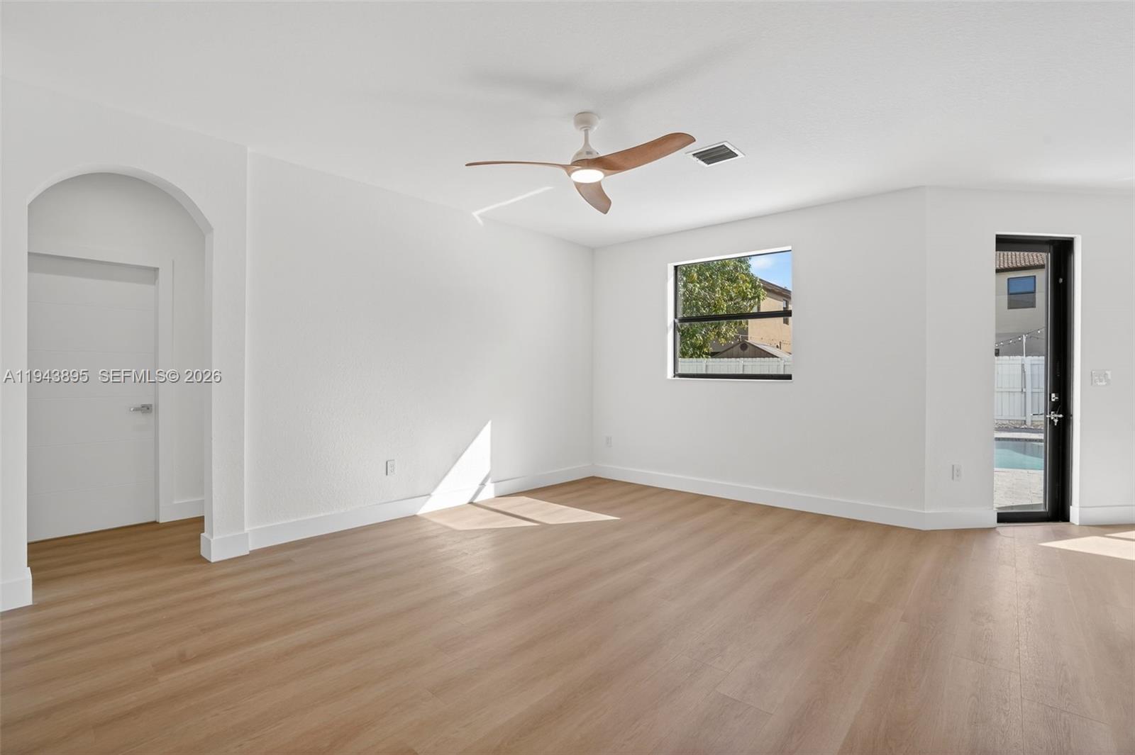 11556 Southwest 234th Street Homestead, FL 33032 - Photo 11 of 44 an empty room with wooden floor cabinet and windows