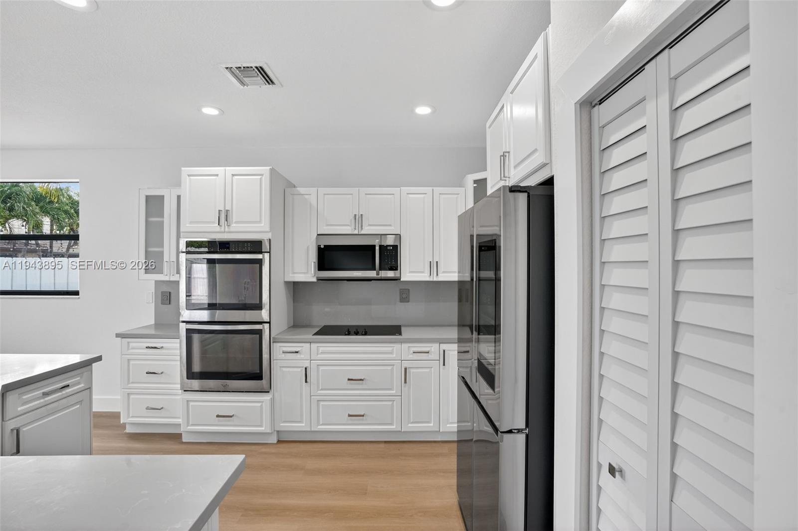 11556 Southwest 234th Street Homestead, FL 33032 - Photo 14 of 44 a kitchen with stainless steel appliances kitchen island granite countertop a refrigerator and a stove top oven