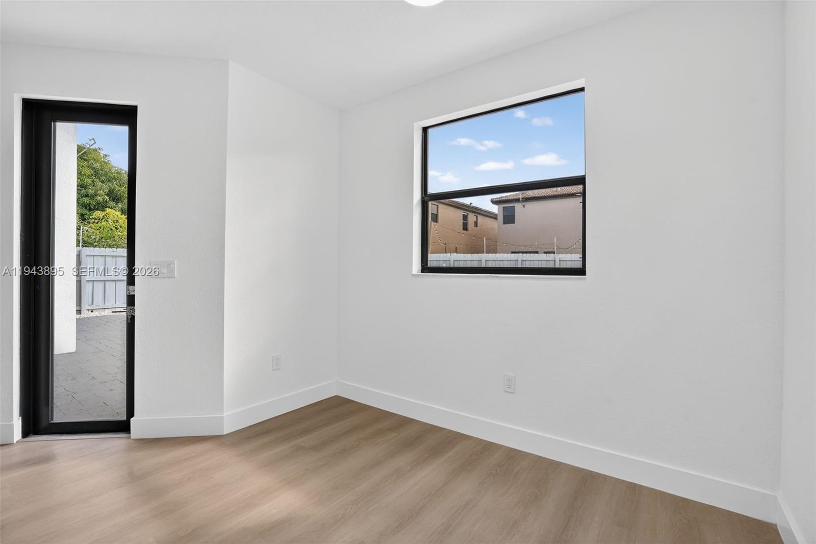 11556 Southwest 234th Street Homestead, FL 33032 - Photo 17 of 44 an empty room with a window and a painting on the wall