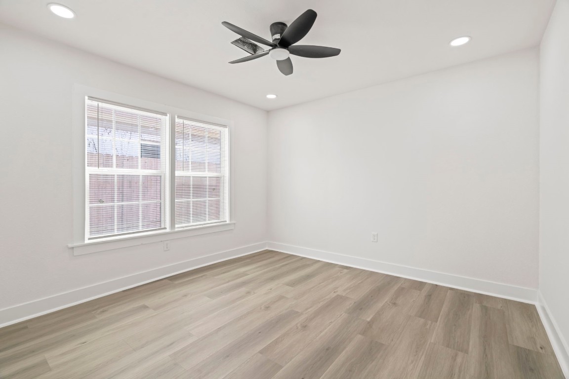 2817 Winbern Street Houston, TX 77004 - Photo 18 of 23 an empty room with wooden floor ceiling fan and windows