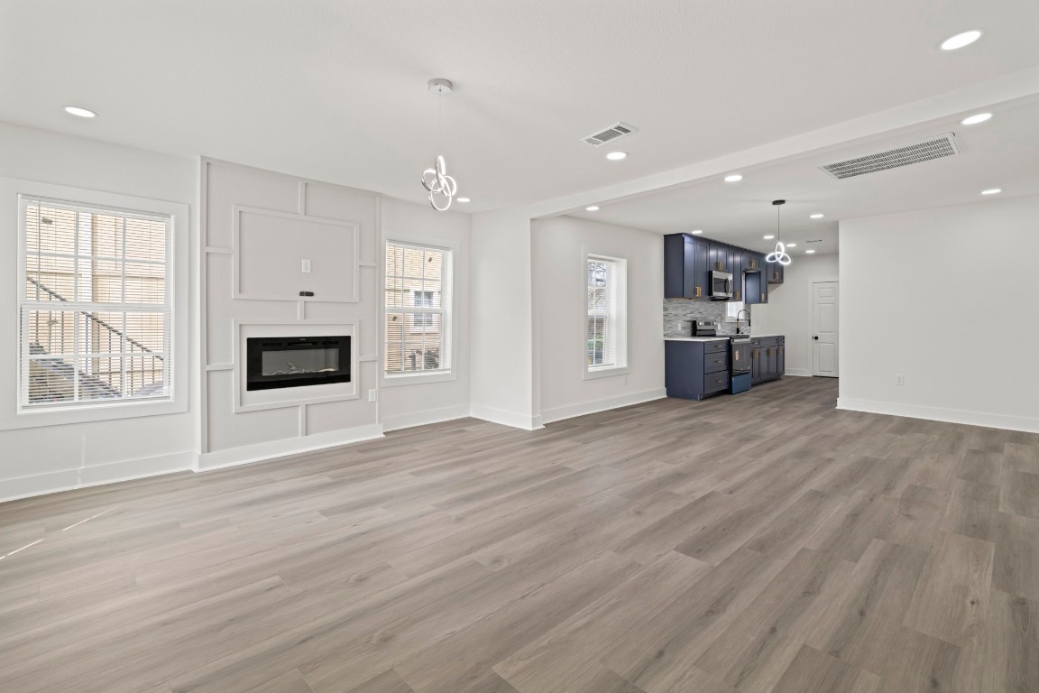 2817 Winbern Street Houston, TX 77004 - Photo 5 of 23 a view of empty room with wooden floor and fireplace