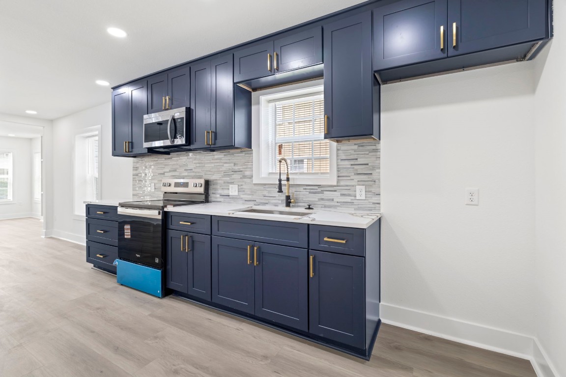 2817 Winbern Street Houston, TX 77004 - Photo 6 of 23 a kitchen with stainless steel appliances granite countertop wooden cabinets a sink and dishwasher