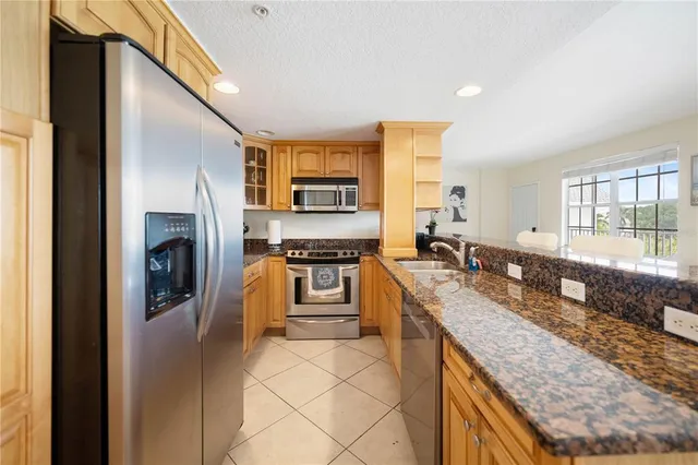 a large kitchen with granite countertop a stove a sink and a refrigerator