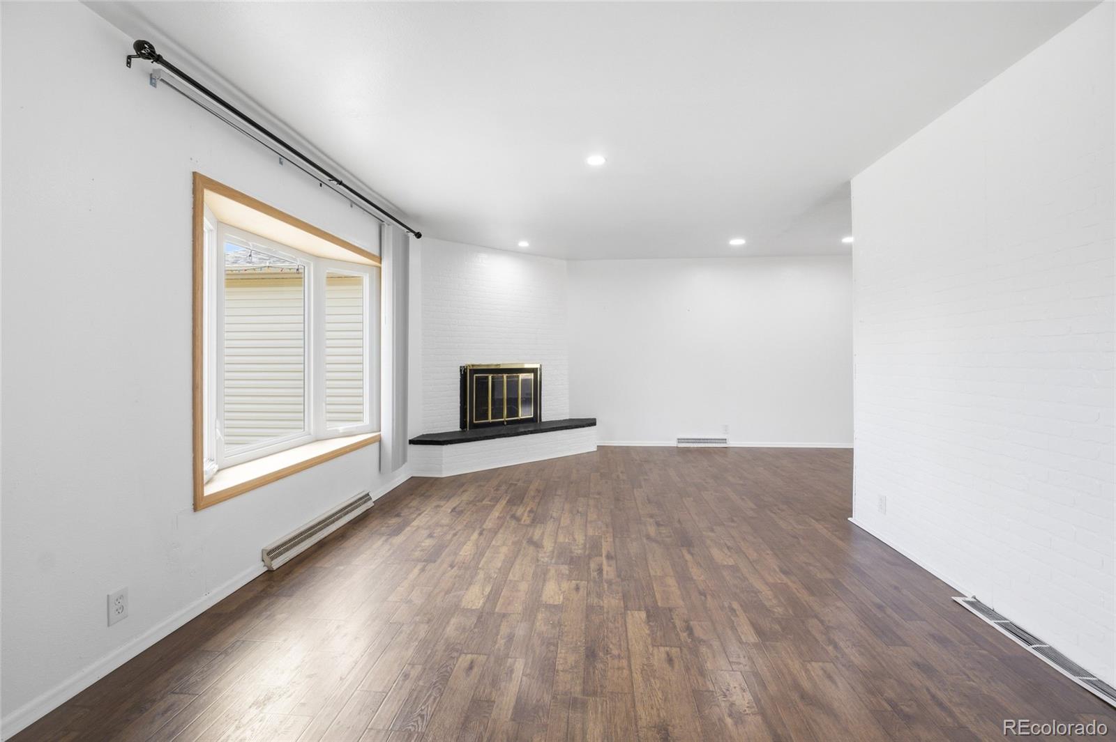 308 Fifth Street Dacono, CO 80514 - Photo 11 of 29 a view of empty room with wooden floor and fan
