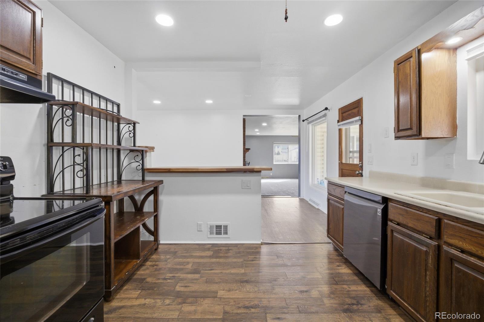 308 Fifth Street Dacono, CO 80514 - Photo 13 of 29 a kitchen with stainless steel appliances granite countertop a stove and a sink