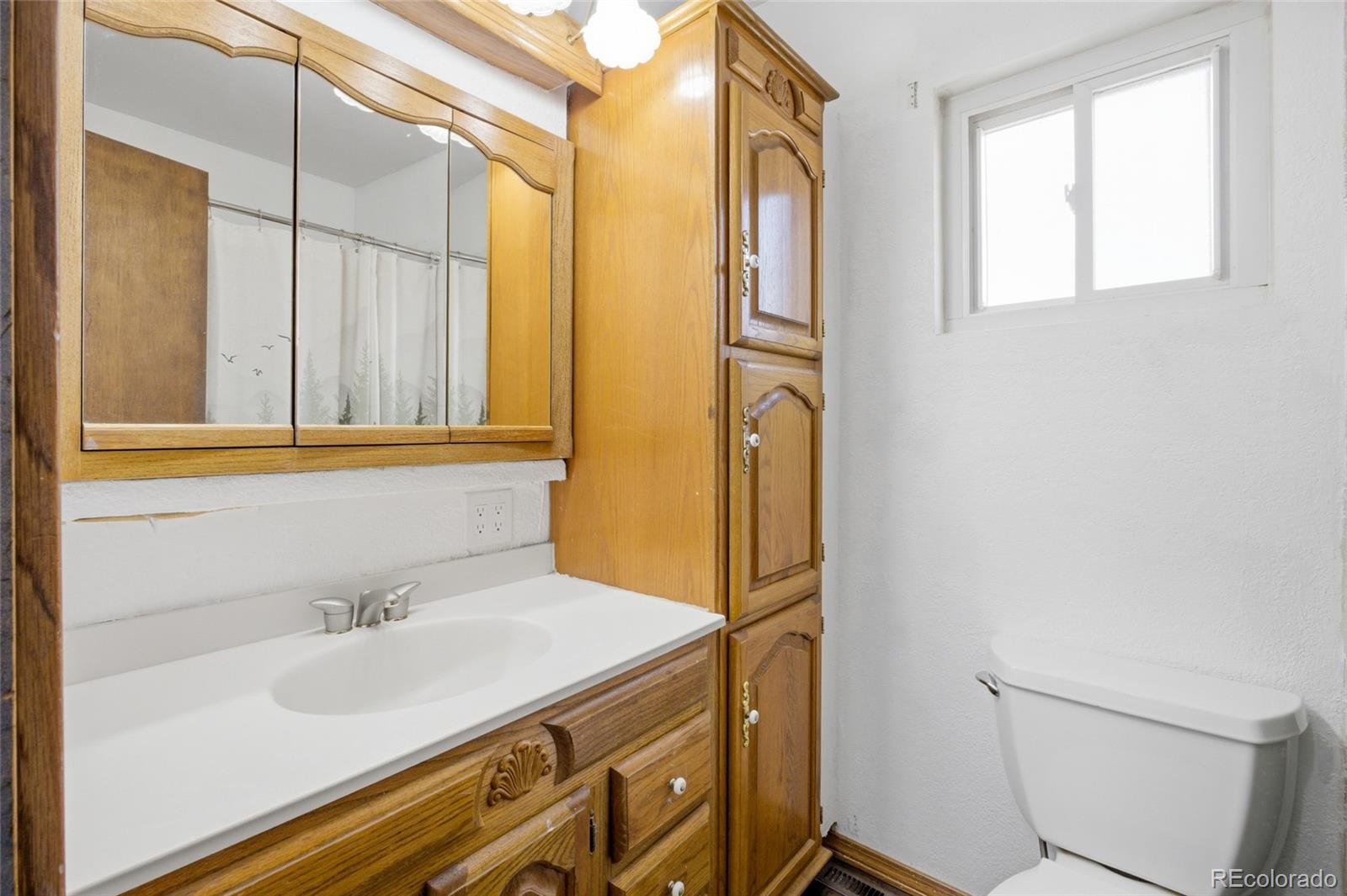 308 Fifth Street Dacono, CO 80514 - Photo 14 of 29 a bathroom with a sink and a mirror