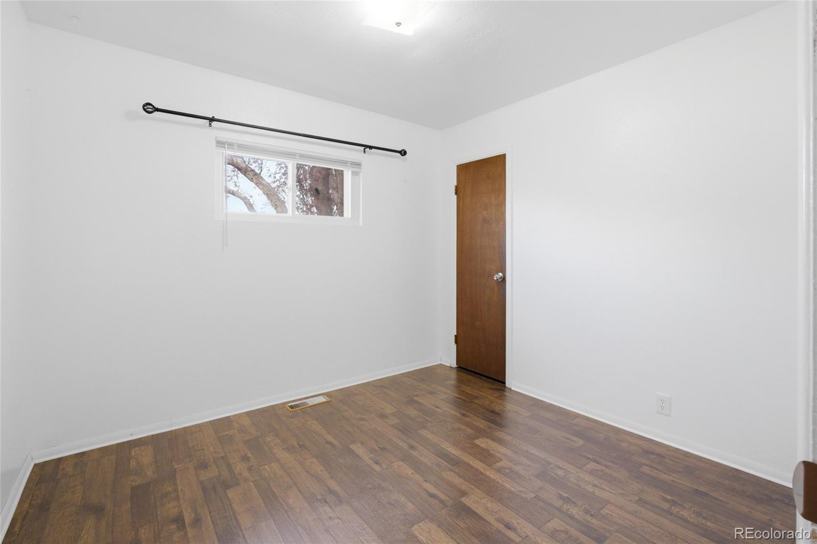 308 Fifth Street Dacono, CO 80514 - Photo 16 of 29 a view of an empty room with wooden floor