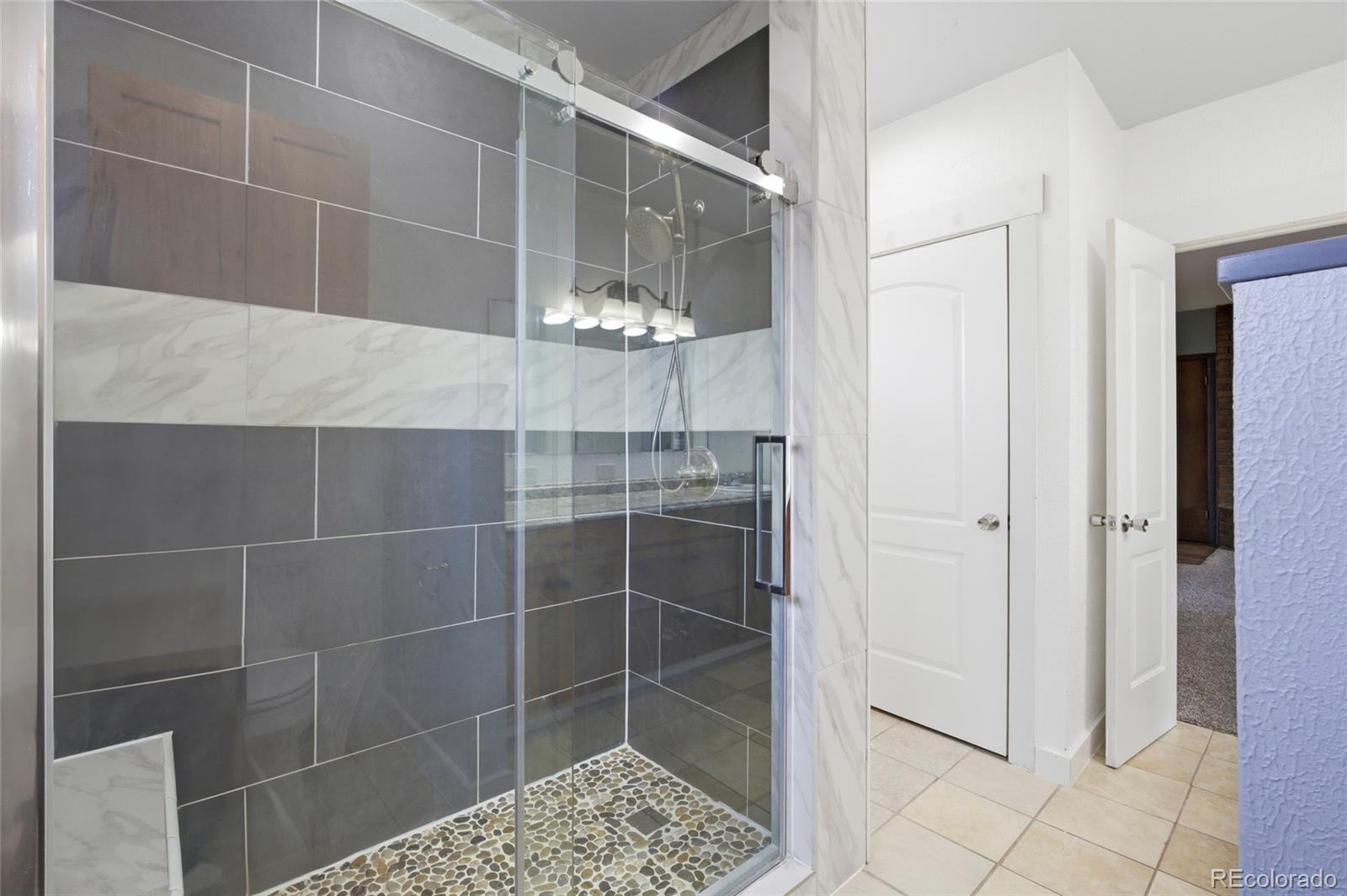 308 Fifth Street Dacono, CO 80514 - Photo 20 of 29 a bathroom with a glass shower door and a sink