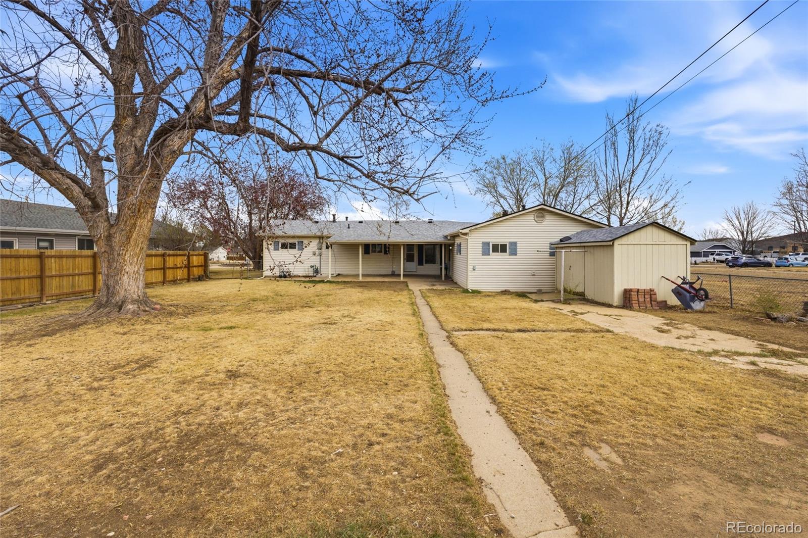 308 Fifth Street Dacono, CO 80514 - Photo 23 of 29 a yellow house with trees in front of it