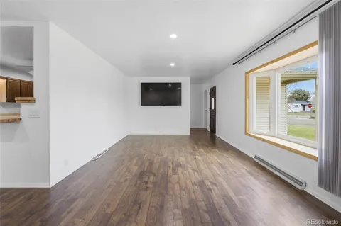 a view of an empty room with wooden floor