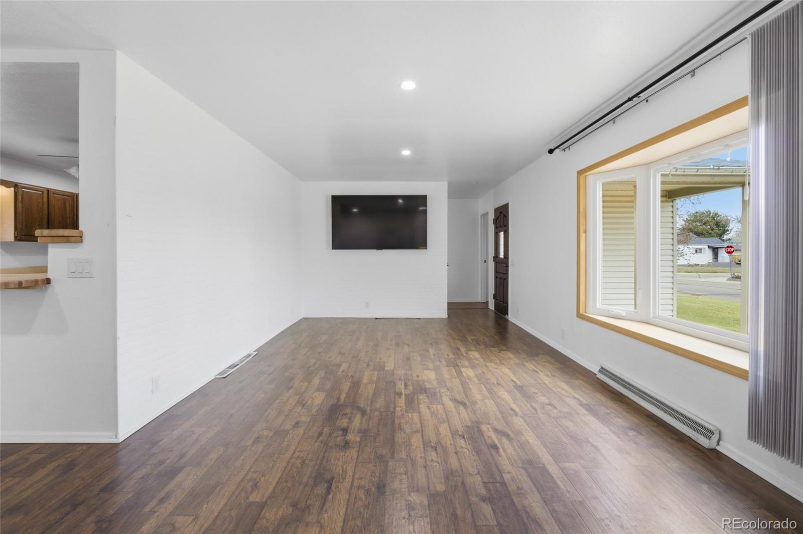 308 Fifth Street Dacono, CO 80514 - Photo 8 of 29 a view of a livingroom with wooden floor and a window