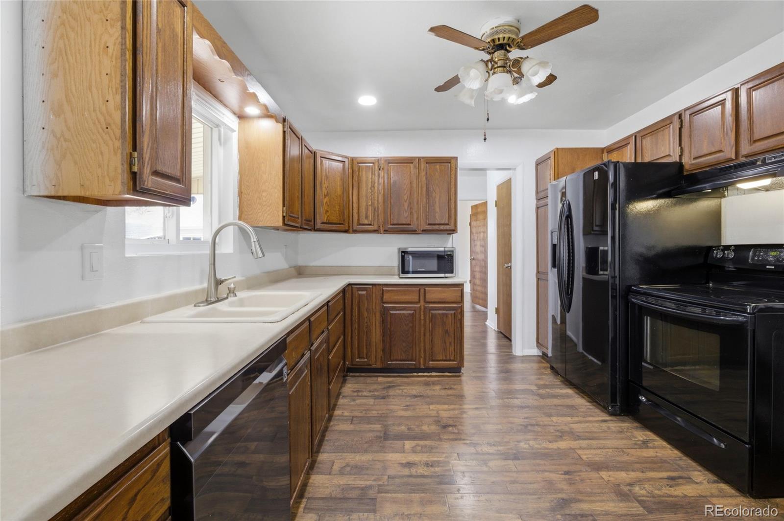 308 Fifth Street Dacono, CO 80514 - Photo 9 of 29 a kitchen with kitchen island granite countertop a sink appliances cabinets and counter space