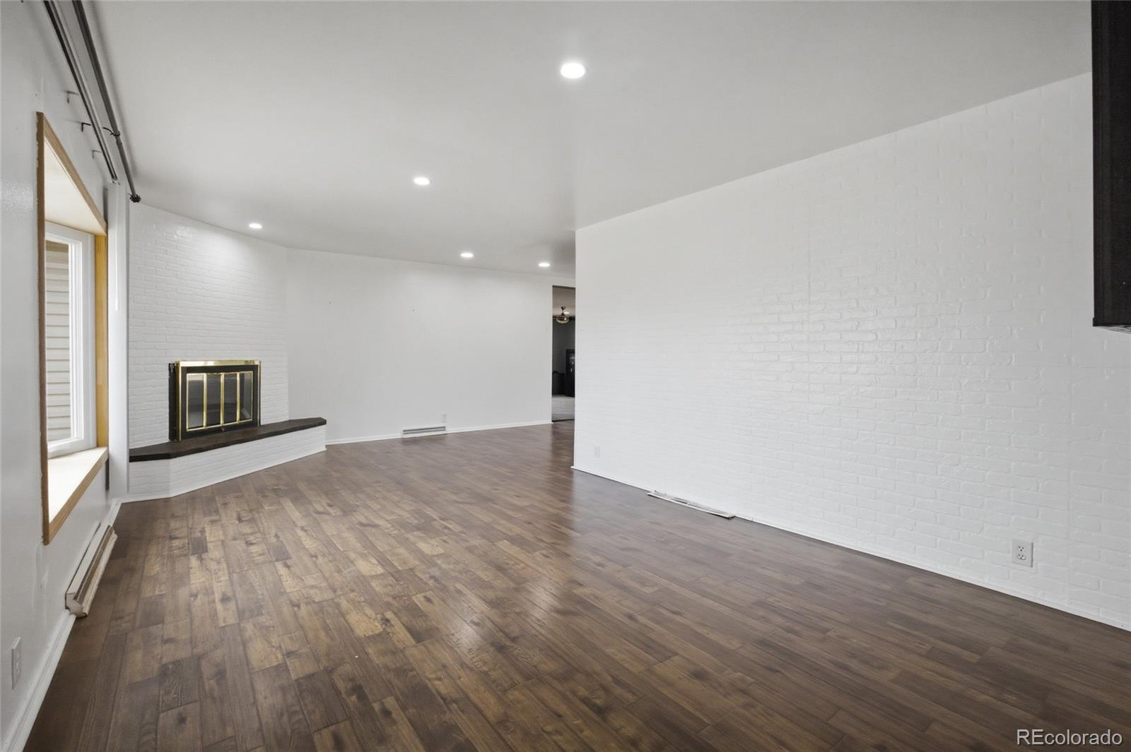 308 Fifth Street Dacono, CO 80514 - Photo 10 of 29 an empty room with wooden floor and a window