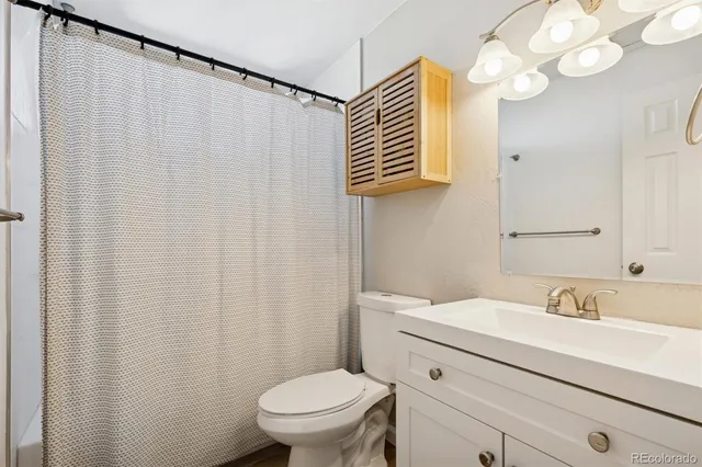 a bathroom with a sink vanity mirror and toilet