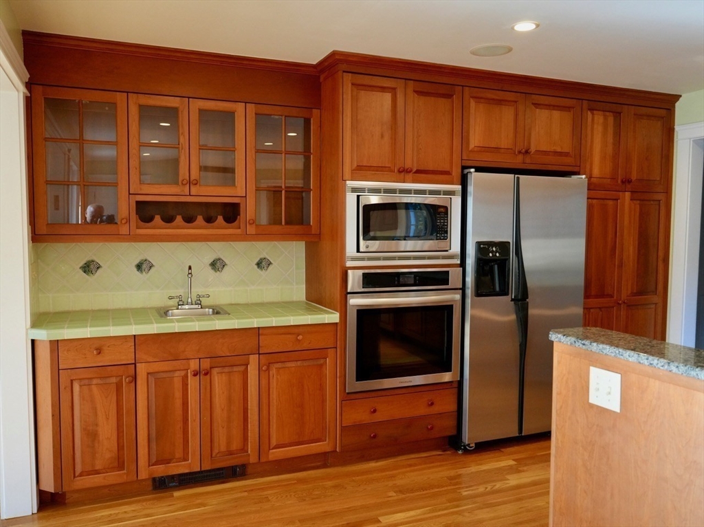 45 Bumblebee Hill Road Falmouth, MA 02540 - Photo 6 of 30 a kitchen with stainless steel appliances granite countertop a refrigerator and a stove top oven