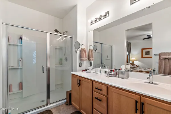 a bathroom with a double vanity sink mirror and shower