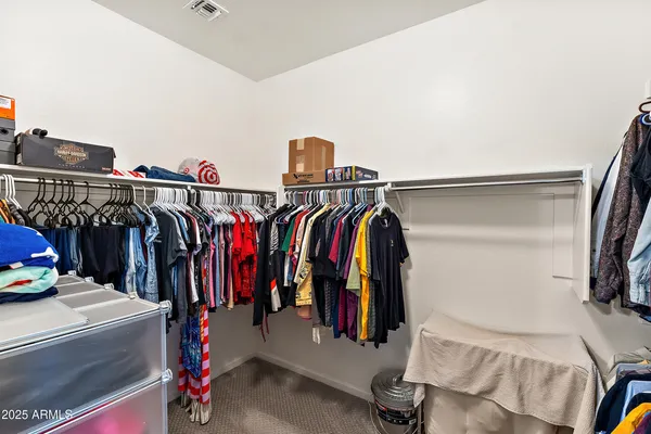 a view of walk in closet with clothes and shoes