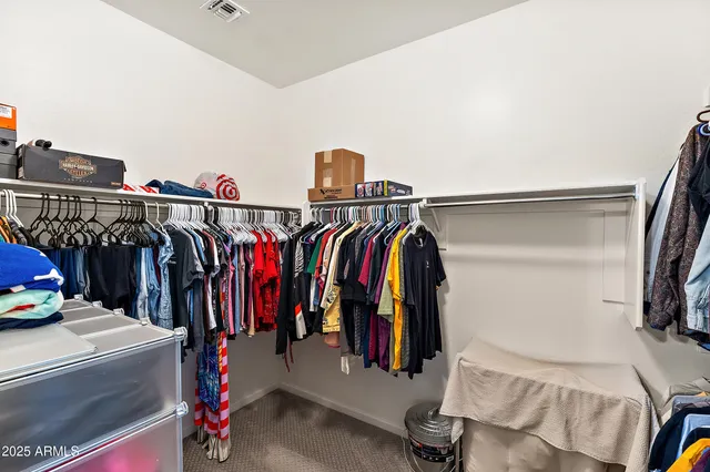 a view of walk in closet with clothes and shoes