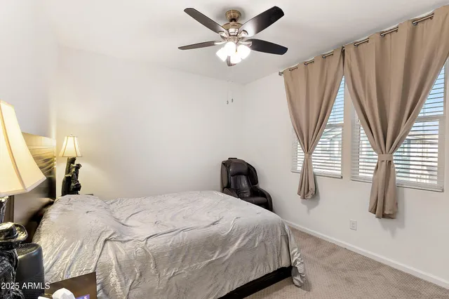 a bedroom with a bed and a large window with wooden floor