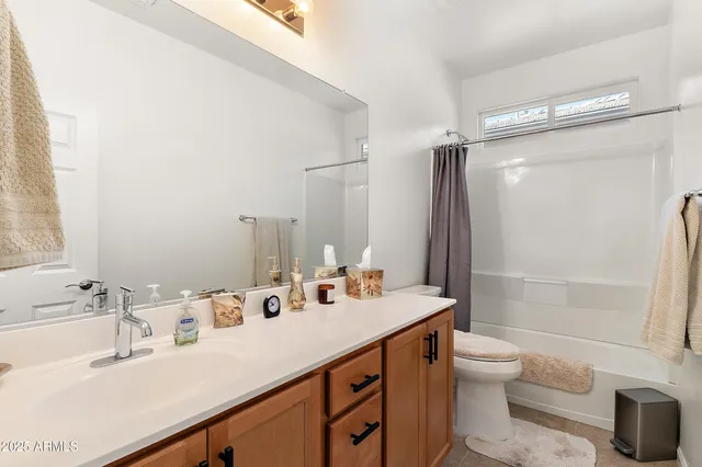 a bathroom with a double vanity sink toilet mirror and shower