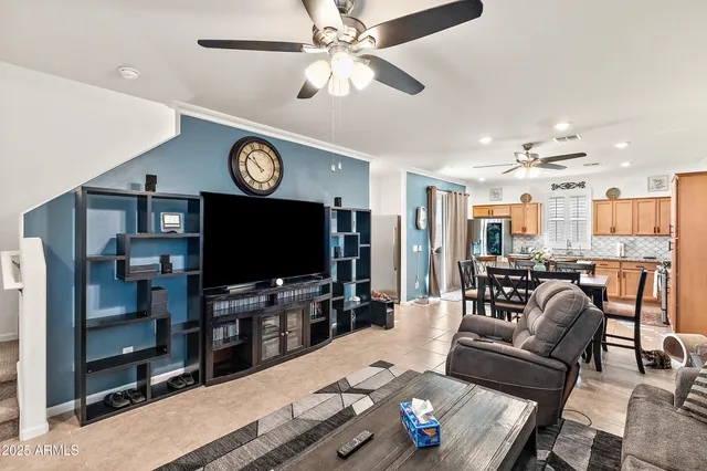 a living room with furniture a flat screen tv and kitchen view