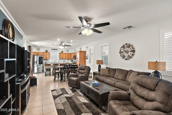a living room with furniture kitchen view and a large window