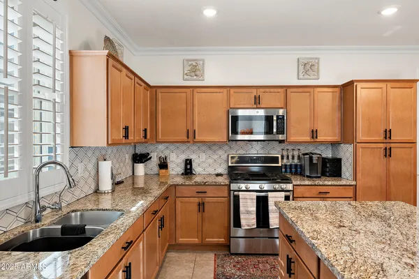 a kitchen with stainless steel appliances granite countertop a sink stove and refrigerator