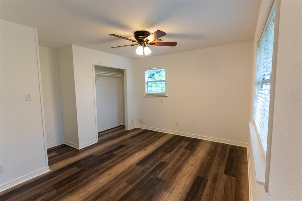 1285 Clark Road Gainesville, TX 76240 - Photo 11 of 20 The property features a room with dark wood-style flooring, white walls, and a ceiling fan with integrated lighting