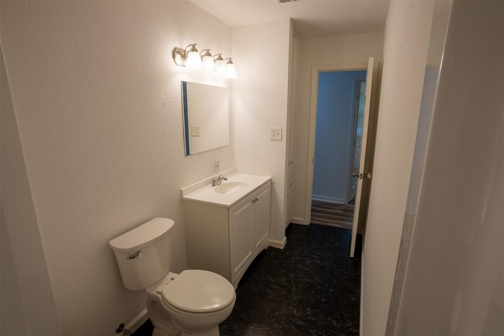 1285 Clark Road Gainesville, TX 76240 - Photo 12 of 20 Bathroom featuring a white vanity with a single sink, a toilet, a mirror, and overhead lighting